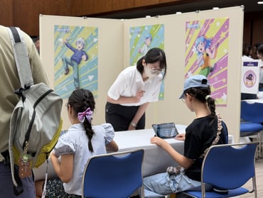 子どもがブースの画面や展示を集中して見つめている姿①