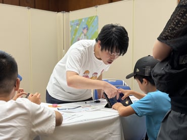 子どもがブースの画面や展示を集中して見つめている姿②