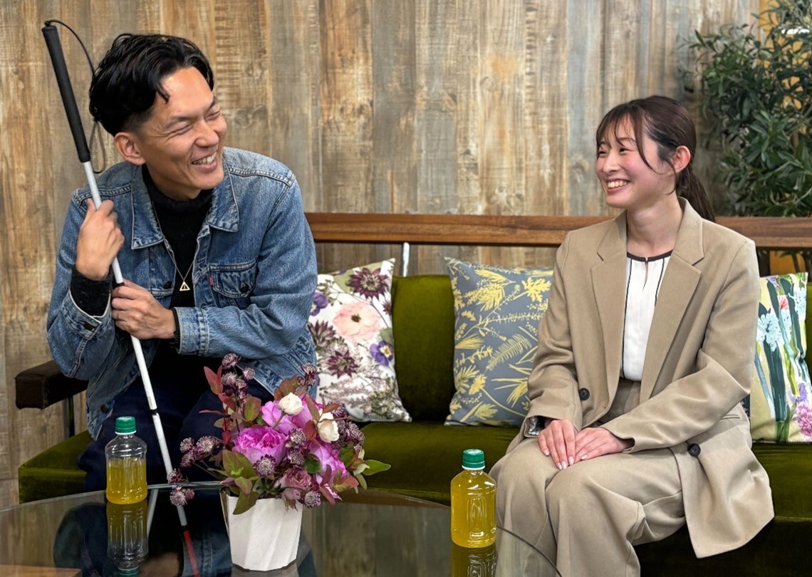 画像:白杖を手に楽しそうに笑う石井さんと、石井さんに笑いかける中野さん。画像終わり
