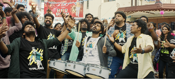 画像：響け情熱のムリダンガムの劇中写真。マーチングのようにスネアドラムを身体の前につけた男性を中心に、若者たちが全身を使って盛り上がっている。画像終わり